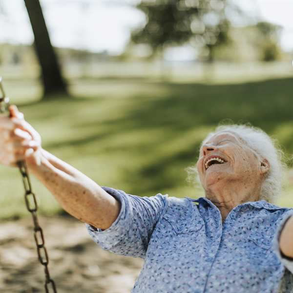 Active senior women swings on the park swing.