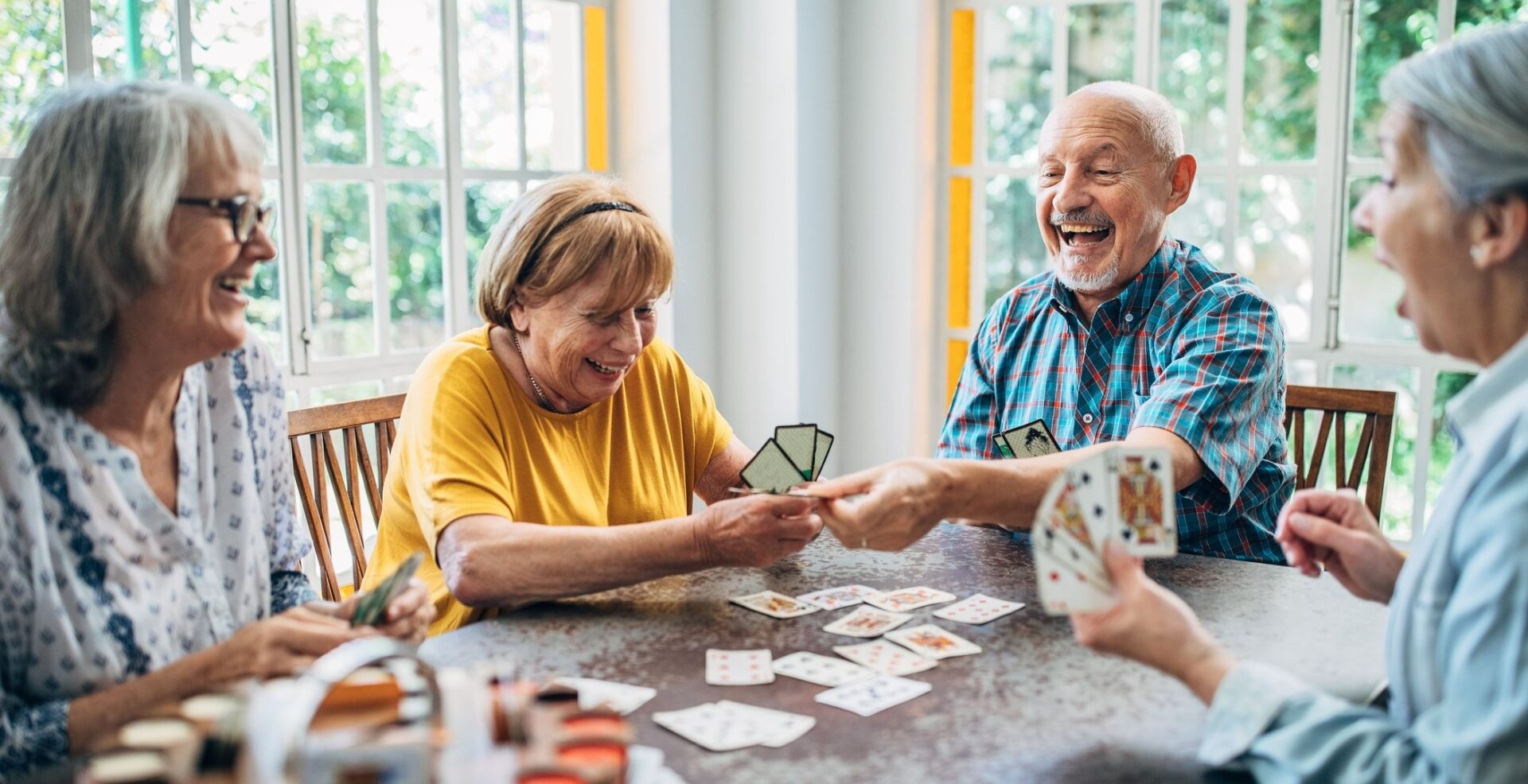 Old people having fun playing cards in nursing home