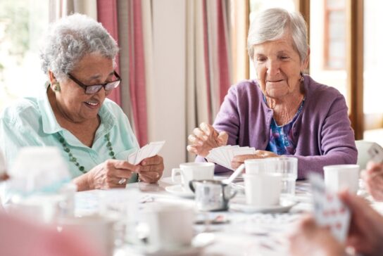 Shot of a group of senior women playing cards together at a retirement home