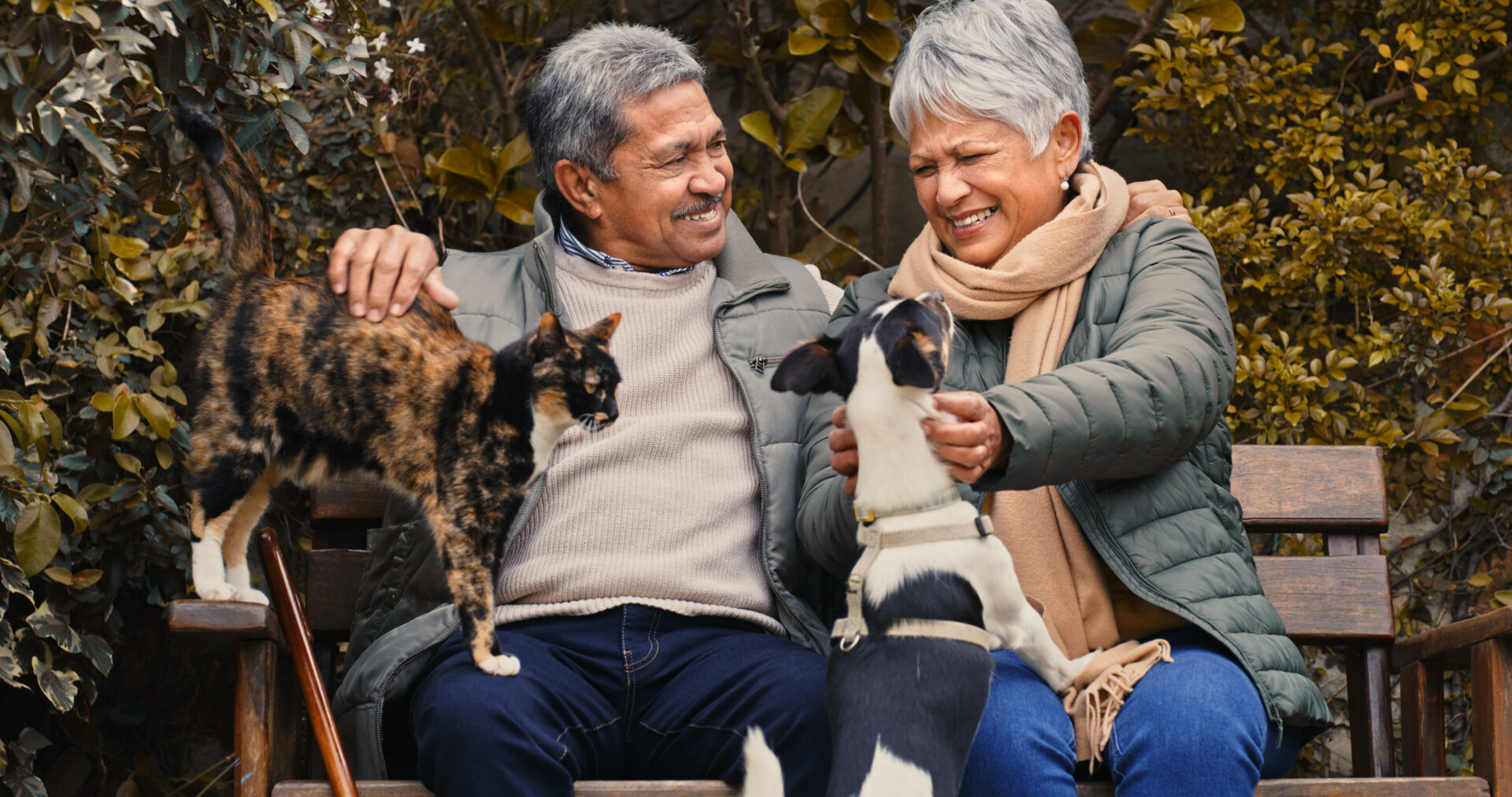Shot of a happy senior couple playing with their pets while relaxing in a garden