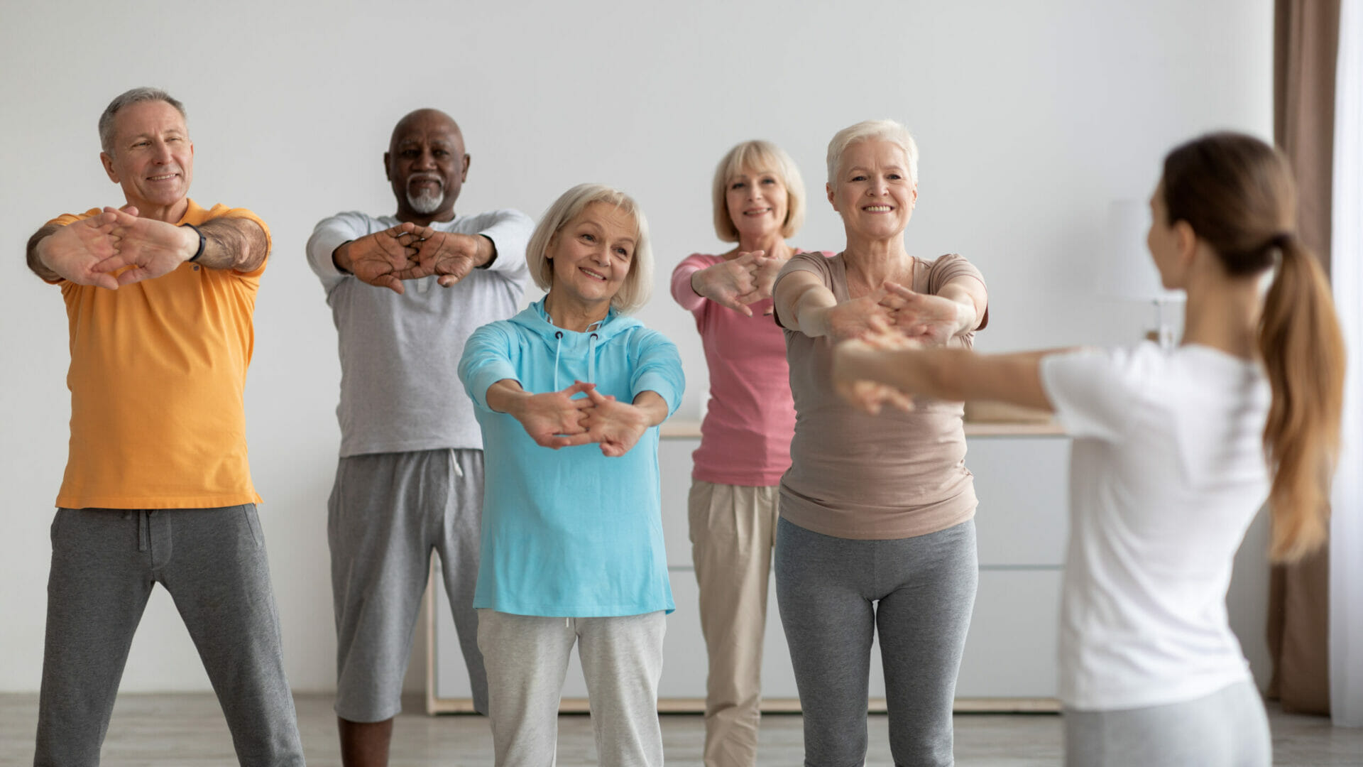 Sporty elderly people having fitness class, training with instructor