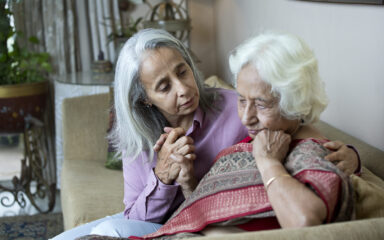 Old woman consoling female friend at home