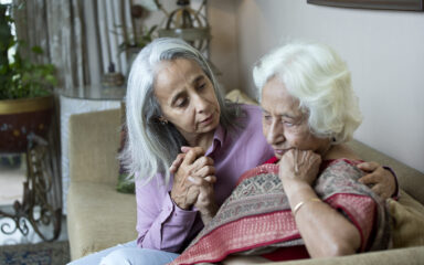 Old woman consoling female friend at home