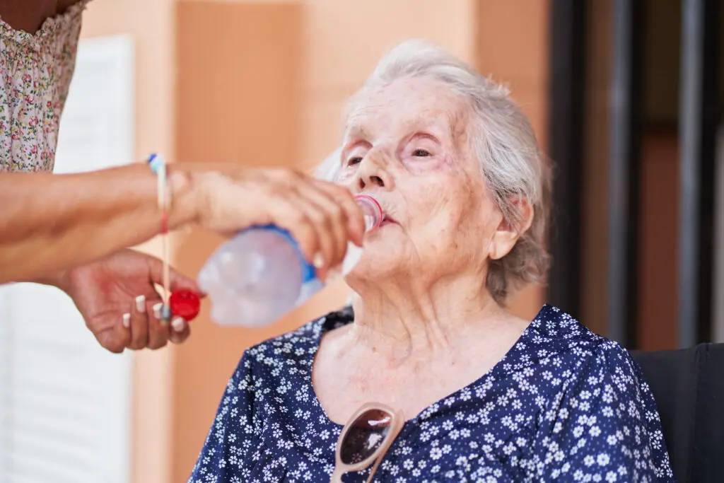 An elderly person enjoying a refreshing water.