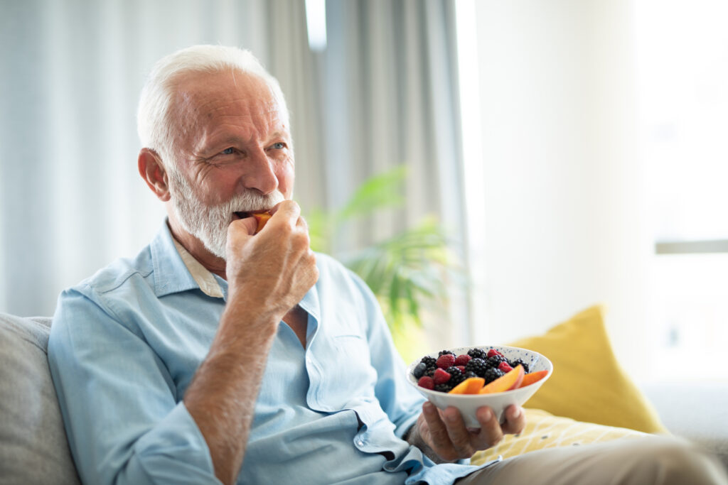 Senior man eating a fruit salad 
