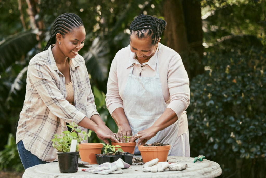 Happy African seniors gardening outdoors.