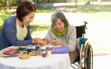 Elderly woman and daughter in the needle crafts occupational therapy for Alzheimer’s or dementia