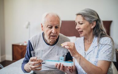 Senior couple arranging medical tablets in a daily pill box