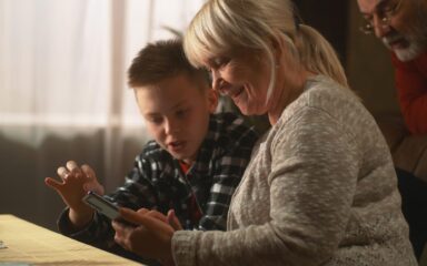Grandson teaching grandparents to use mobile phone