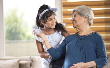 Girl embracing grandmother at home