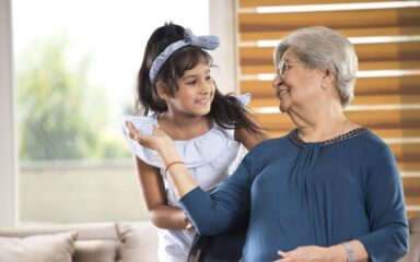 Girl embracing grandmother at home