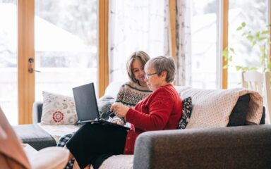Grandmother and teenager Christmas shopping on laptop