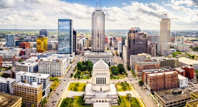 Indiana Statehouse and Indianapolis skyline on a sunny afternoon.