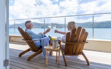 Mature couple drinking wine out on the deck.