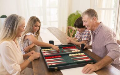 Grandparents and grandchildren playing backgammon