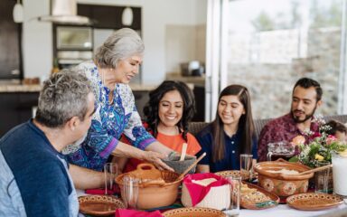 Multi generation Latin American family having family lunch together in summer