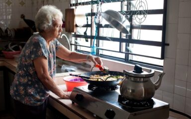 Senior Asian woman preparing food in kitchen