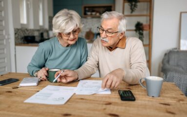 Mature couple going over financial bills in their domestic kitchen