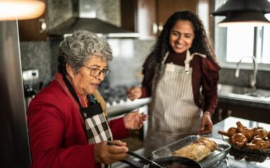 Senior woman with her daughter preparing food at kitchen counter at home