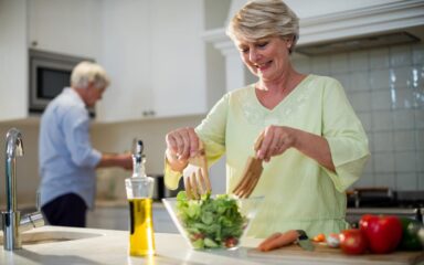 Senior woman preparing vegetable salad