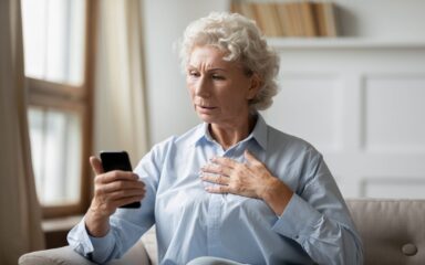 Anxious mature woman distressed by bad news on cellphone