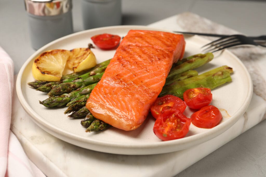 Grilled salmon with asparagus, tomatoes and lemon