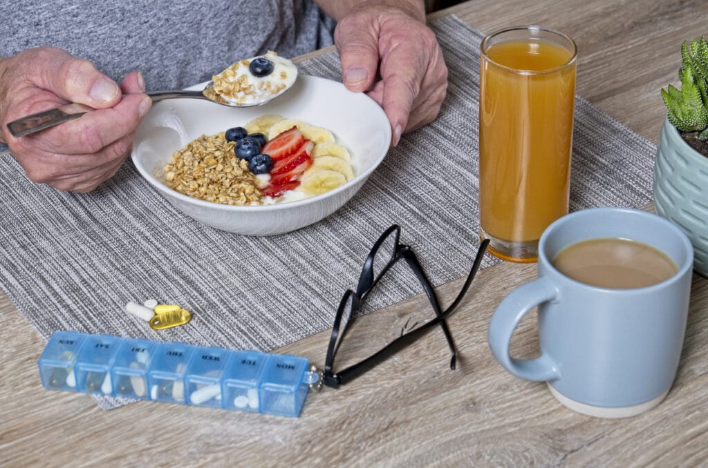 A senior having muesli and yoghurt breakfast with orange juice as immune-boosting foods