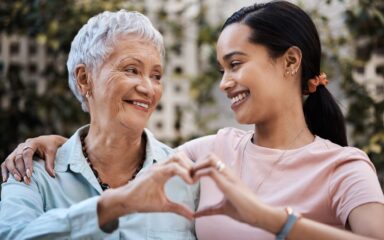 Shot of a senior woman and her daughter making a heart shape with their hands in the garden at home