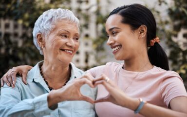 Shot of a senior woman and her daughter making a heart shape with their hands in the garden at home