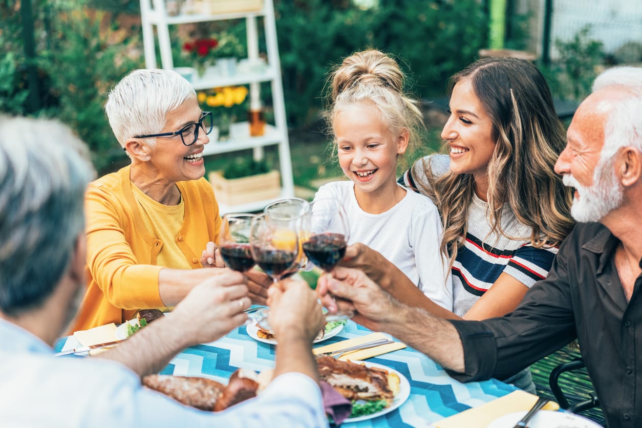 Celebrating Grandparents: Activities for National Grandparents Day. Happy big family celebrating Thanksgiving day outdoor.