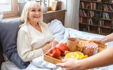 Nurse taking care of senior woman breakfast retirement concept