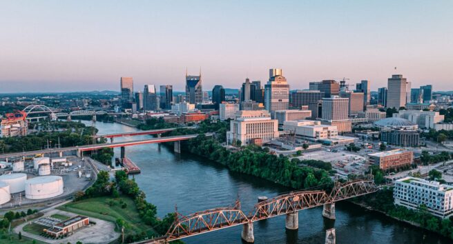 Aerial View of Railroad Bridge and James Robertson Parkway Bridge Downtown Nashville, Tennessee on a Sunny Autumn Evening from Across the Cumberland River