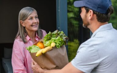 Grocery store delivery man delivering food to woman home.