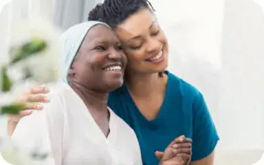 A caregiver embraces a senior resident with warmth and compassion at the living facility.