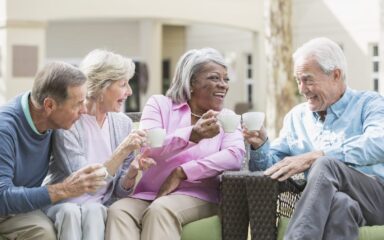 Multiracial senior friends outdoors drinking coffee
